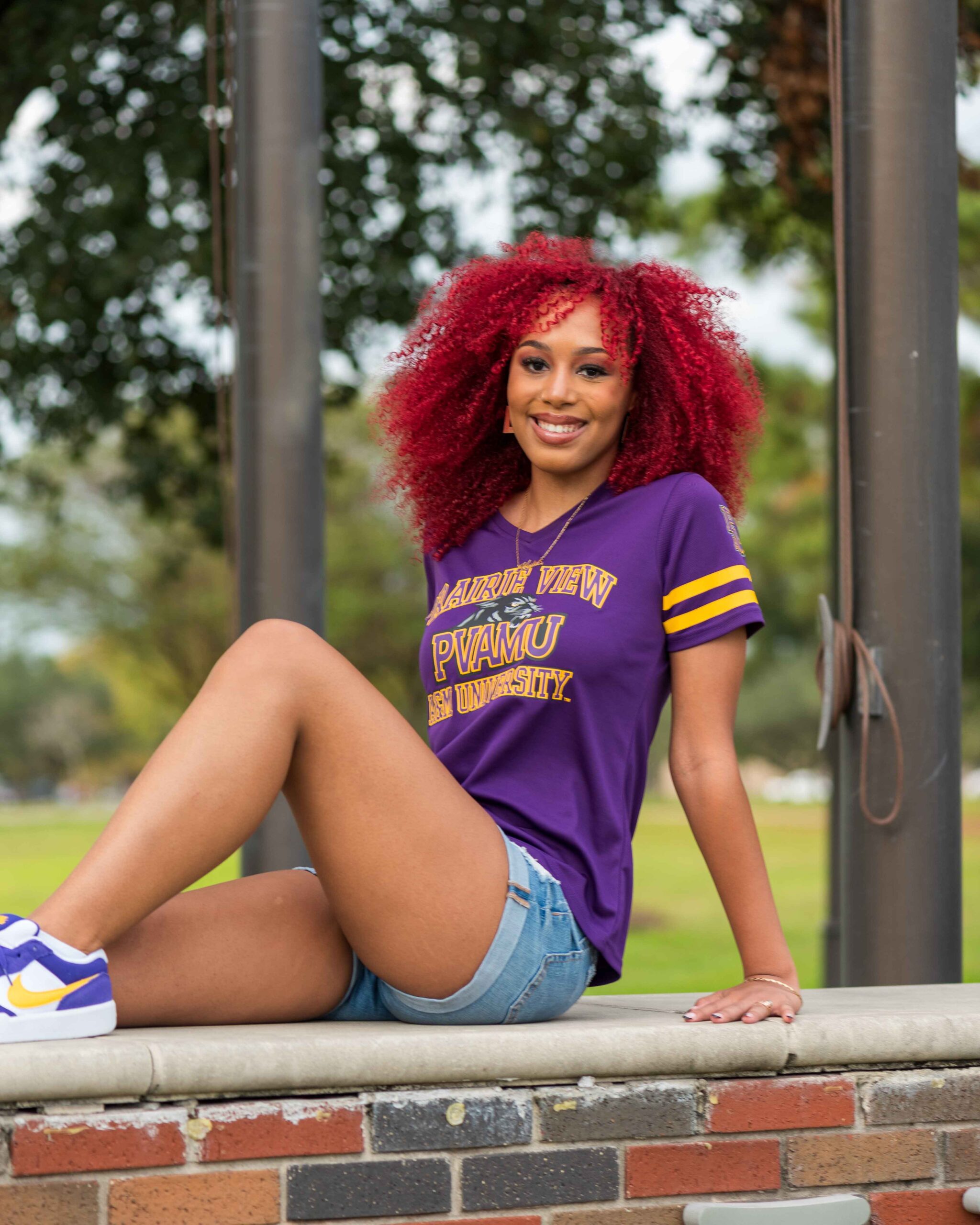 College grad posing for grad photos at PVAMU